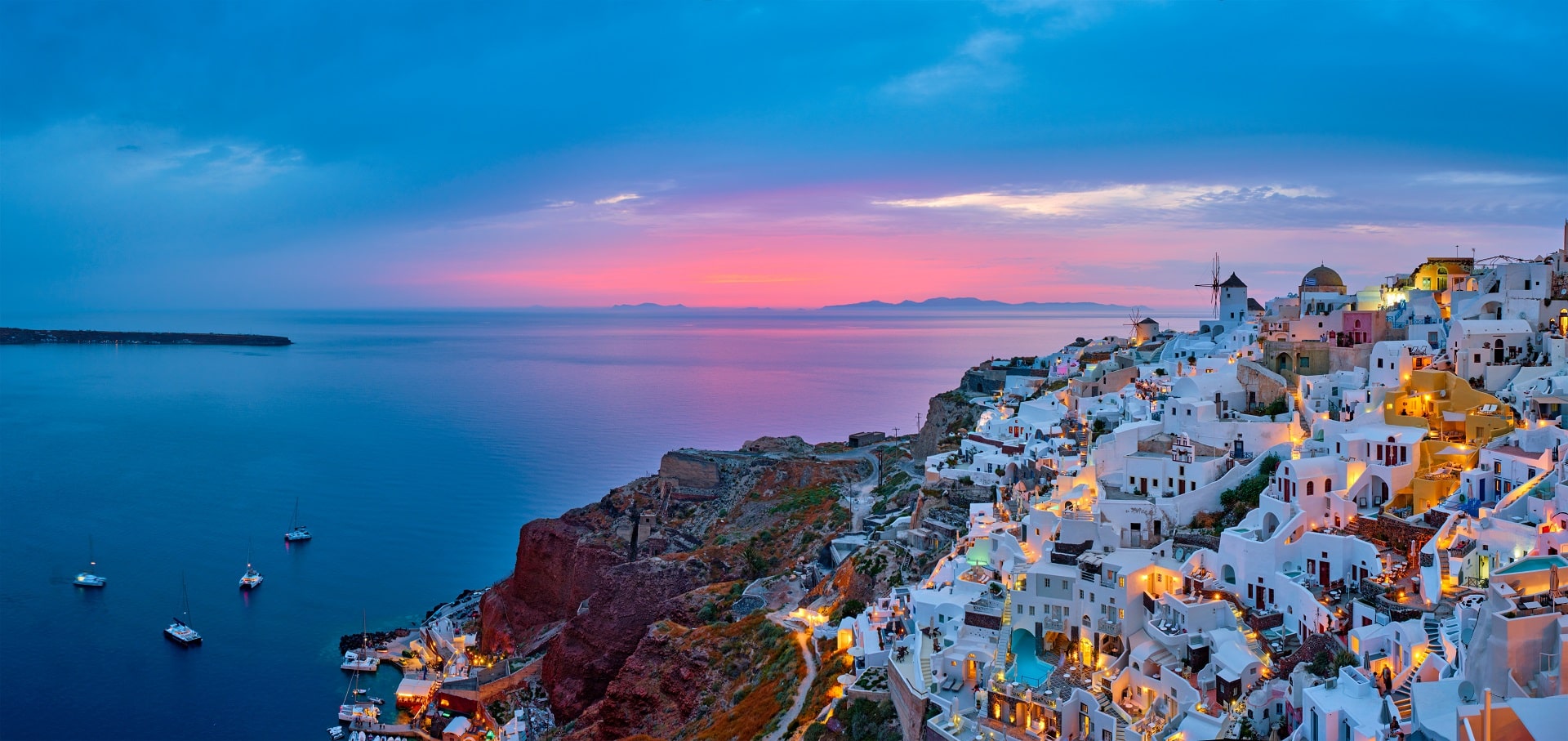 Oia village with traditional white houses and windmills in Santorini island