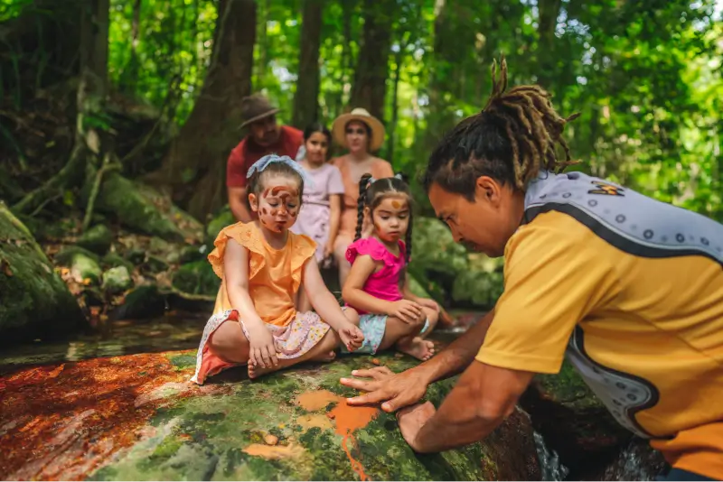 A family make art on a rock in a forest