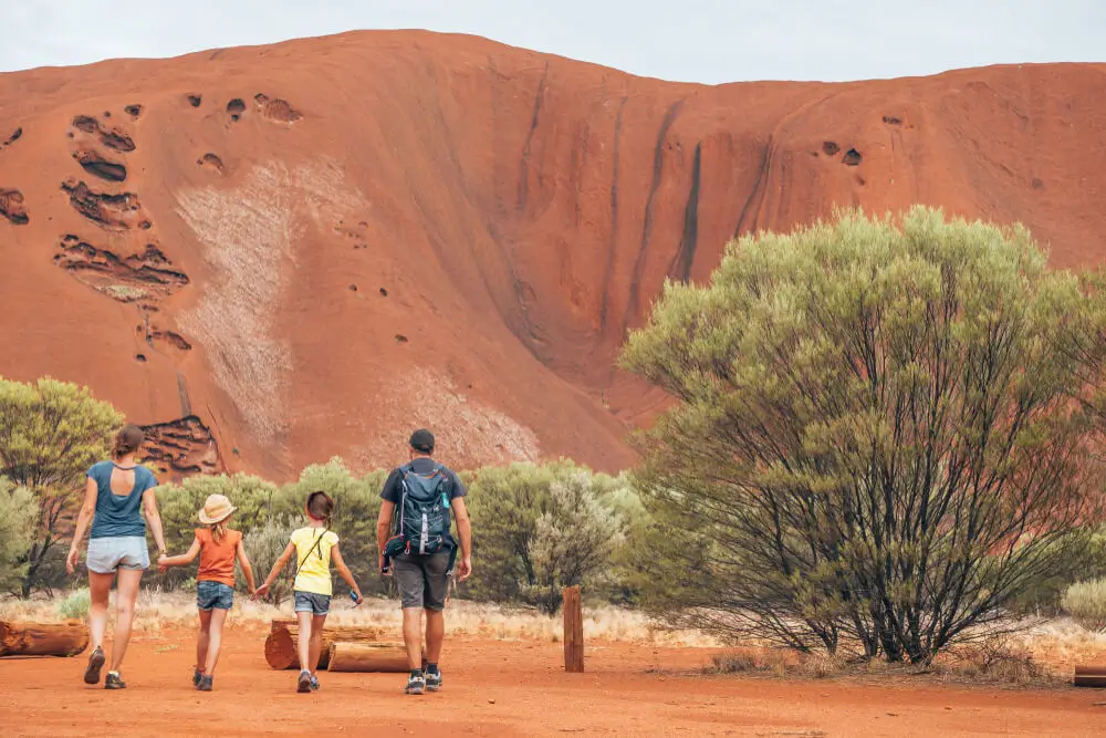 A family walking towards Uluru, Northern Territory